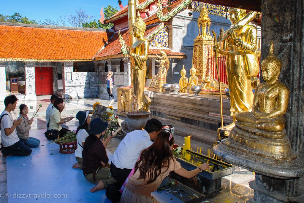 buddhist people praying in a temple 